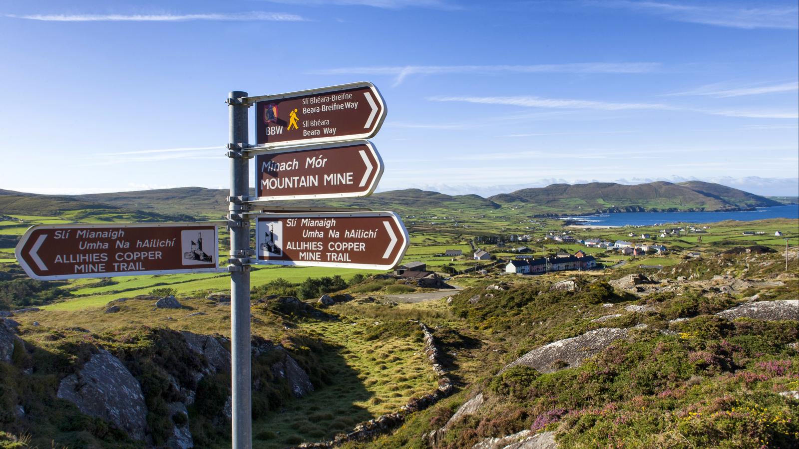 Sign post for Mountain trail with view of mountains and sea in background