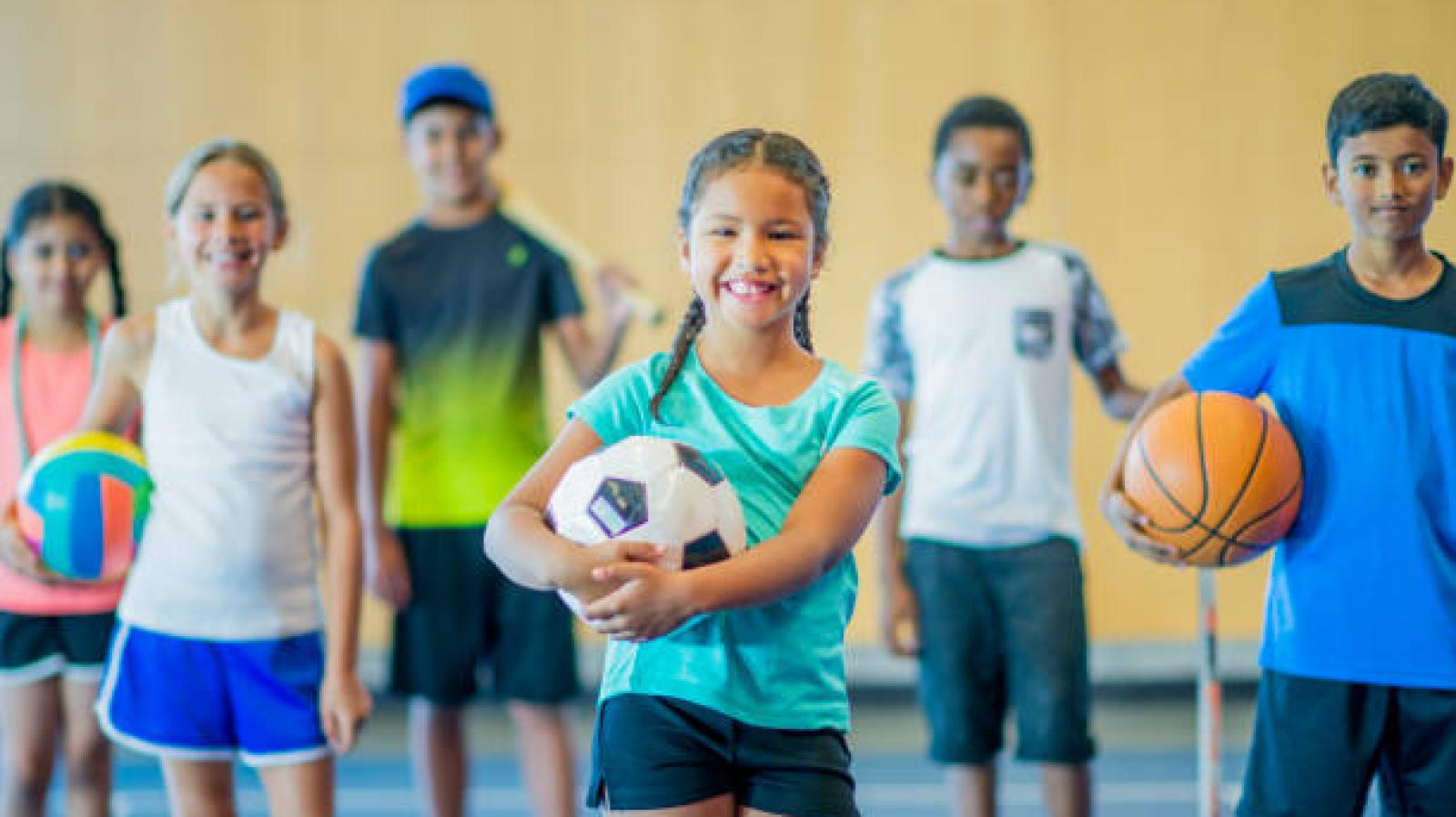 children holding sports equipment